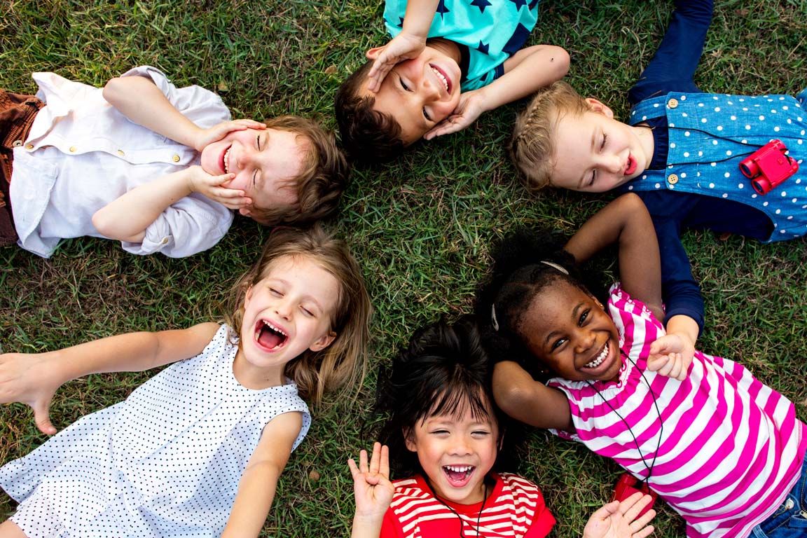 Children lying down and laughing in a circle